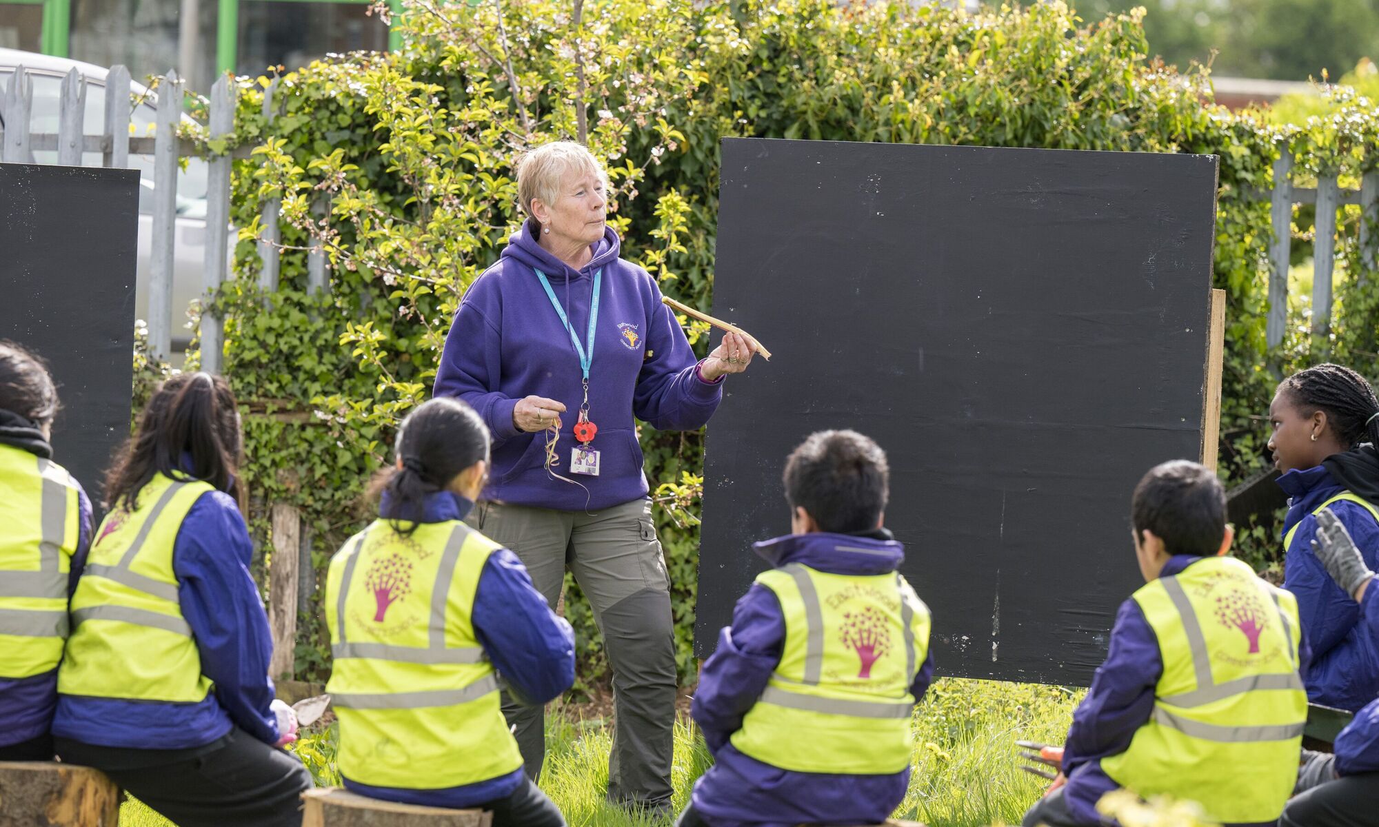 Eastwood Community School - pupils learning outside with high vis jackets on